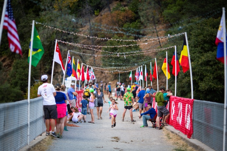 As runners in a marathon go by, volunteers hand them small cone